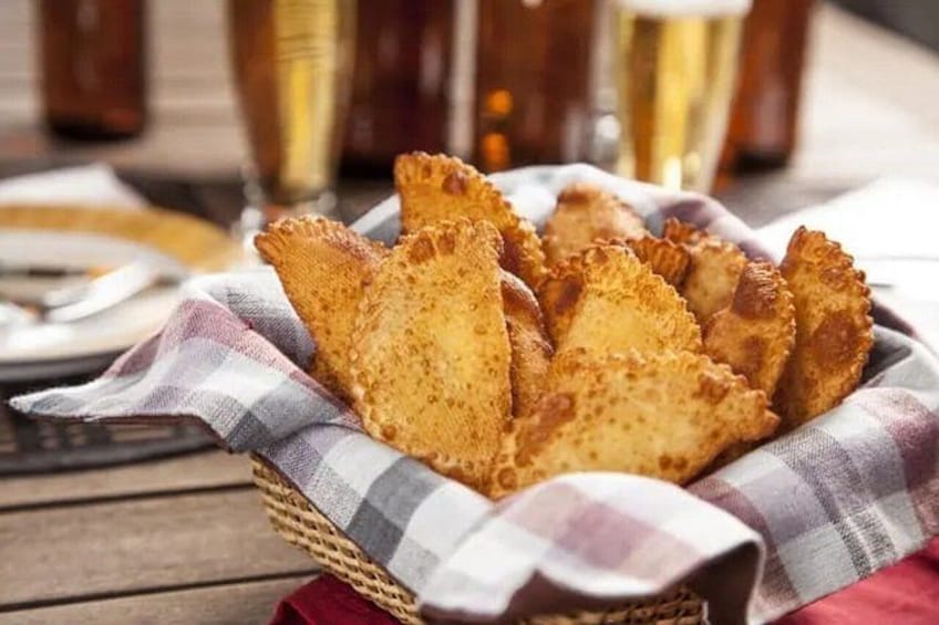 A basket of fried snacks on a table with a checkered cloth. 2