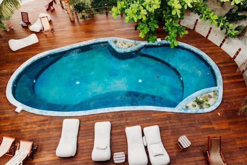A swimming pool with lounge chairs and a wooden deck. 2