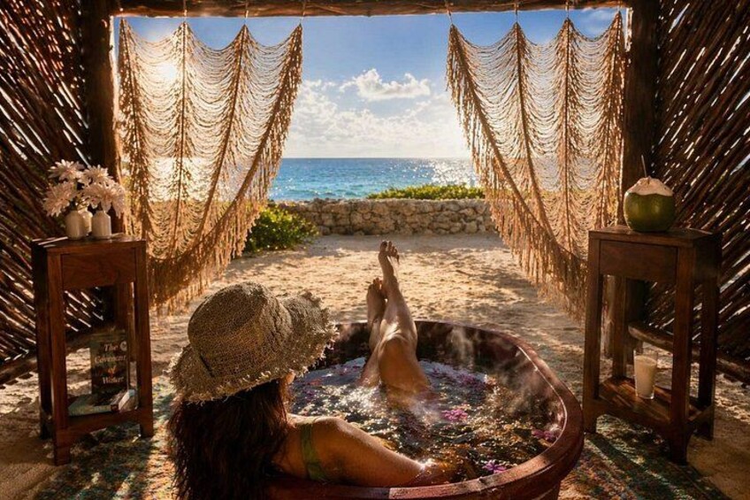 Iemand ontspant in een jacuzzi aan het strand, met een hangmat en tiki-decoraties. 1