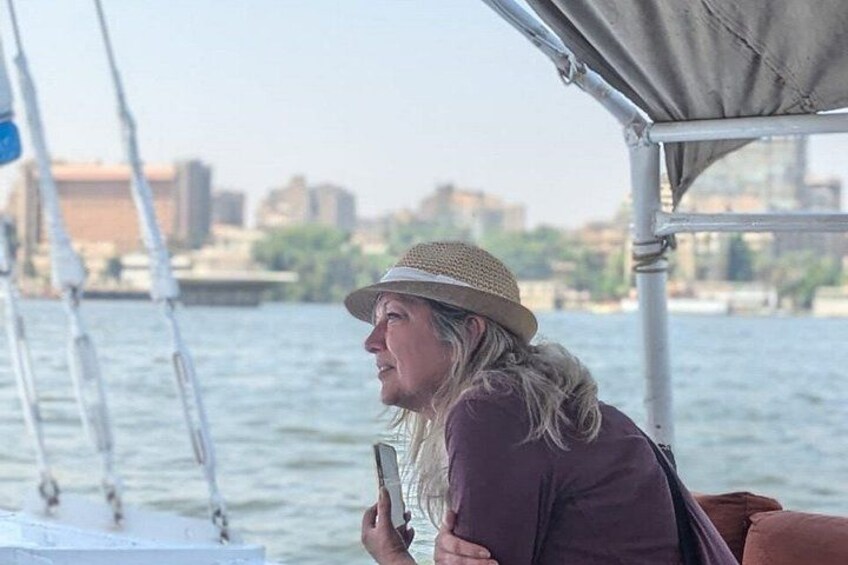 Una persona en un barco, con sombrero, y un paisaje urbano al fondo. 3