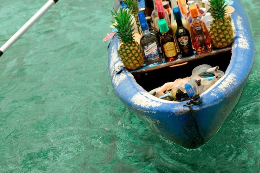 Un bateau bleu, avec des ananas et des bouteilles flottant sur une eau claire. 2