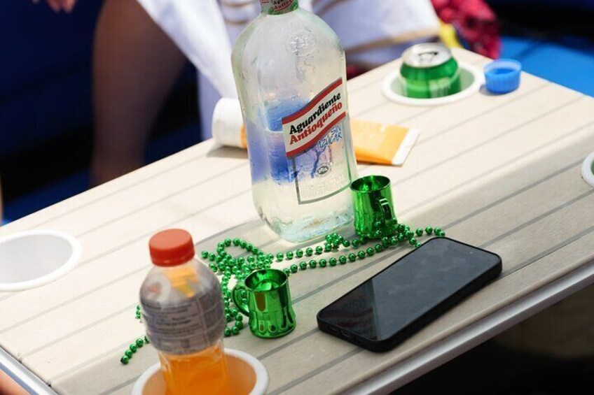 Une table avec une bouteille d’eau Aquafina, un téléphone intelligent, des perles vertes et un petit récipient contenant un liquide orange. 3