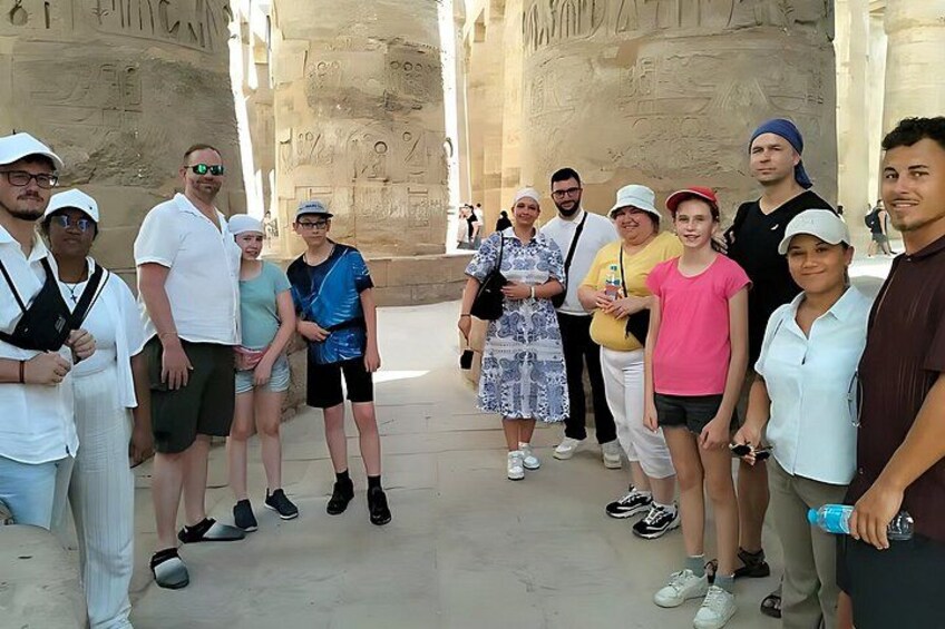 Un grupo de personas frente a columnas egipcias antiguas. 3
