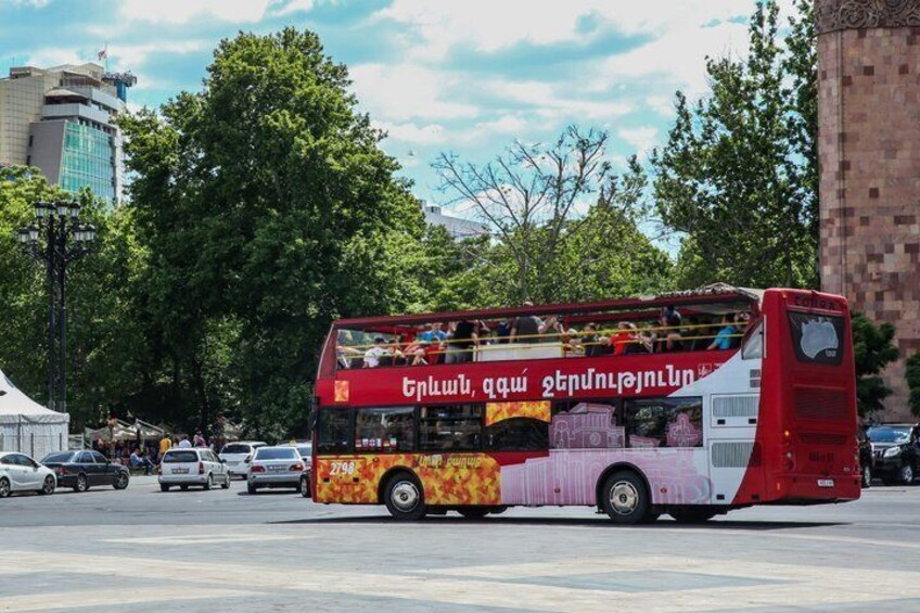 Ein roter Doppeldeckerbus mit Fahrgästen, geparkt in einer Stadtstraße. 5
