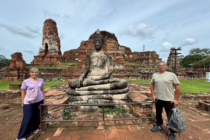 Une grande statue de Bouddha se dresse sur un site historique, avec des ruines antiques en arrière-plan. 5