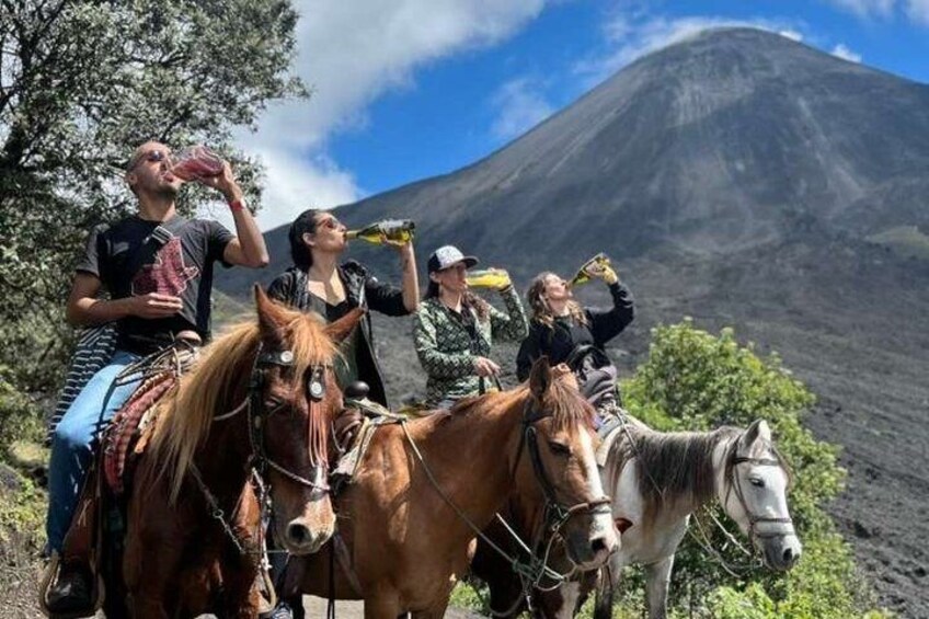 Un groupe de personnes à cheval, avec un volcan en arrière-plan. 5