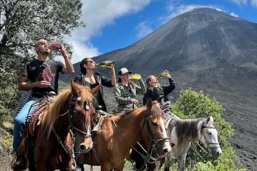 A group of people on horseback with a volcano in the background. 5