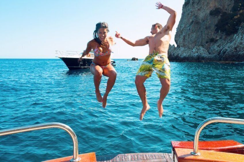 Dos personas saltando al mar desde un bote. 2
