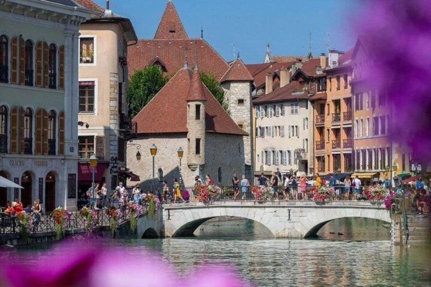 Un ponte sull'acqua, con persone che passeggiano, circondato da edifici storici. 1