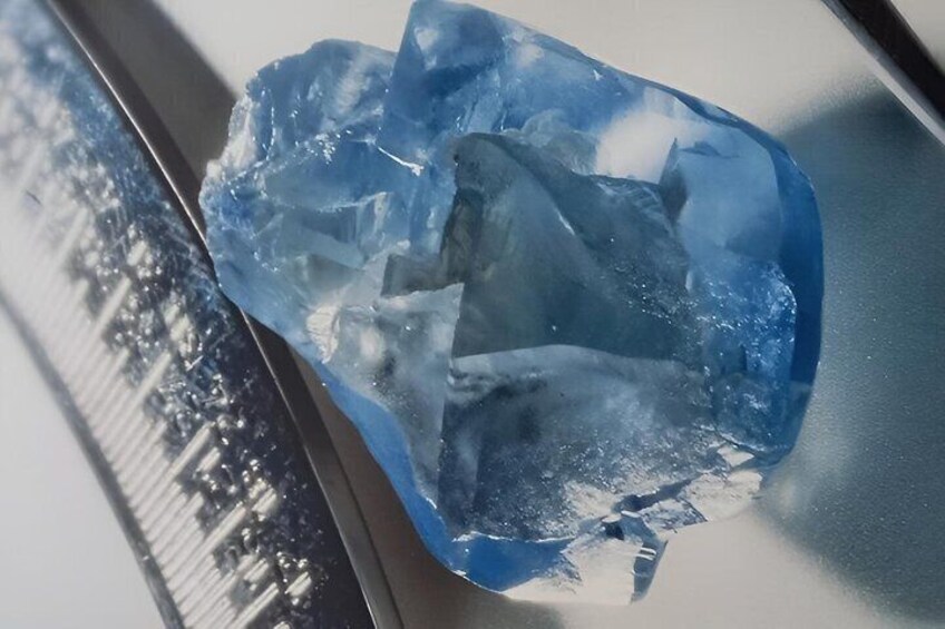 Un cristal bleu posé sur une surface réfléchissante. 2