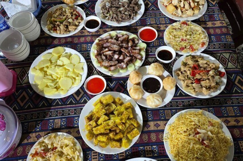 A table with various dishes including rice, meat, and vegetables, with multiple small bowls of sauces. 4