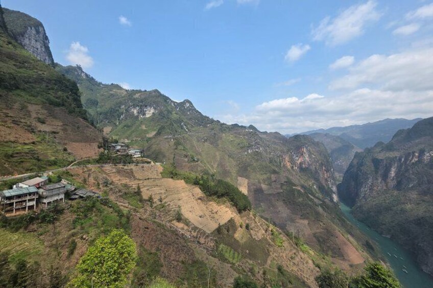 A mountainous landscape with terraced fields and a river. 5