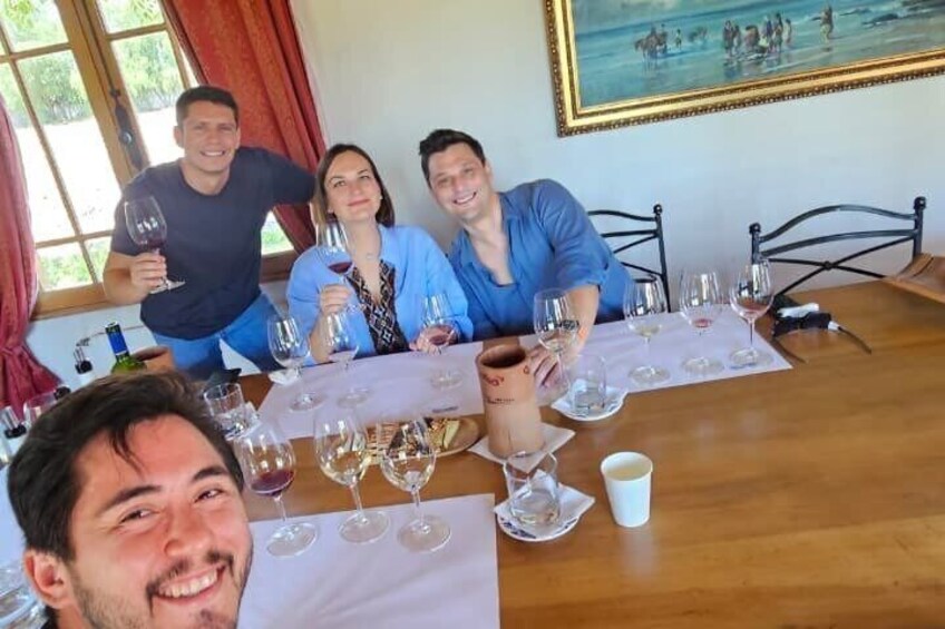 A group of people sitting around a table with wine glasses. 3