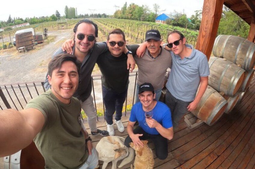 A group of people on a wooden deck with barrels in the background. 4