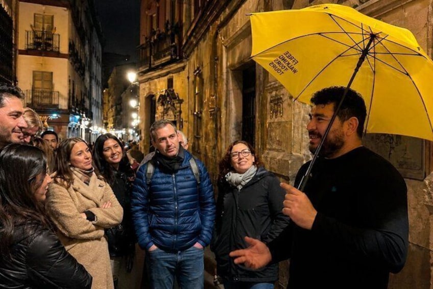 A group of people standing on a street at night. 5