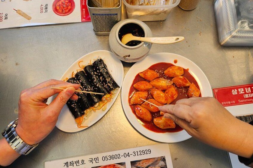 Una persona sosteniendo un plato de comida, con un bol de salsa y una cuchara sobre la mesa. 3