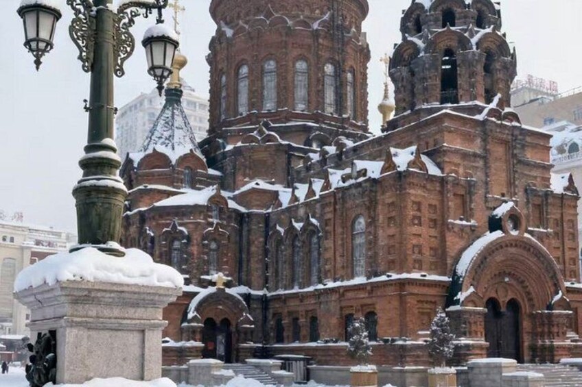 A historic building with intricate architecture, snow-covered statues, and a lamppost. 3