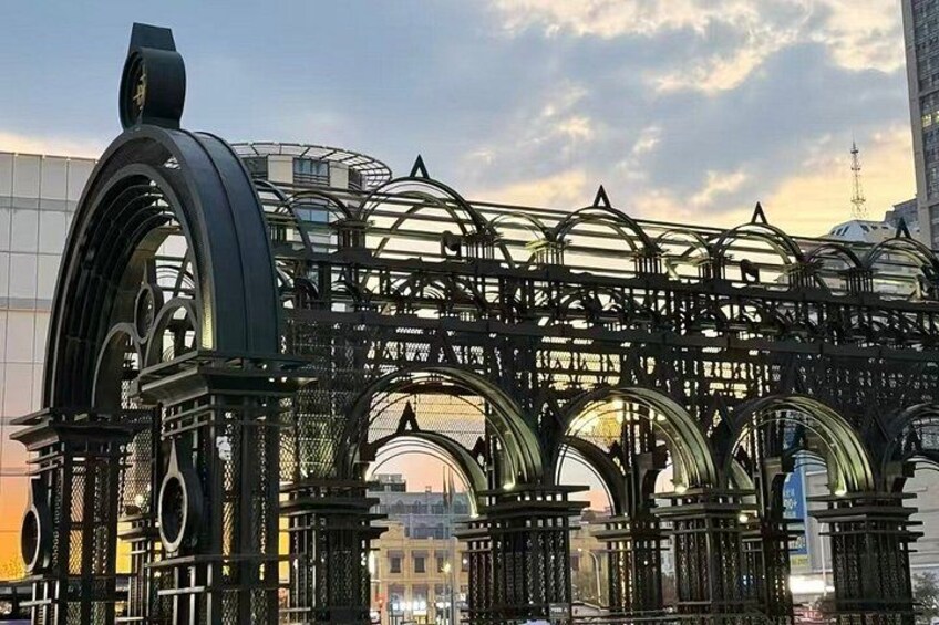 A large metal structure with arches and a complex framework, likely a bridge or part of a building. 1