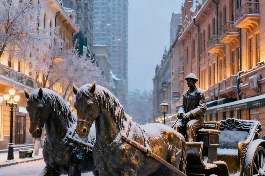A snow-covered horse-drawn carriage with a statue of a soldier in the background. 2