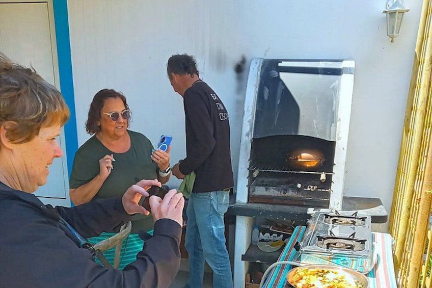 People around a barbecue grill with food. 2