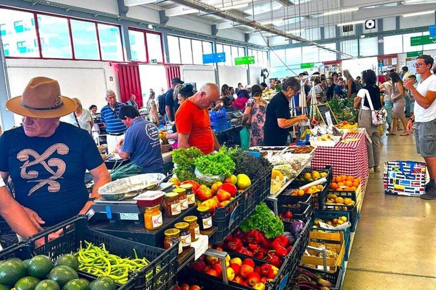 Un mercado interior concurrido y varios puestos que venden frutas, verduras y otros productos frescos. 2