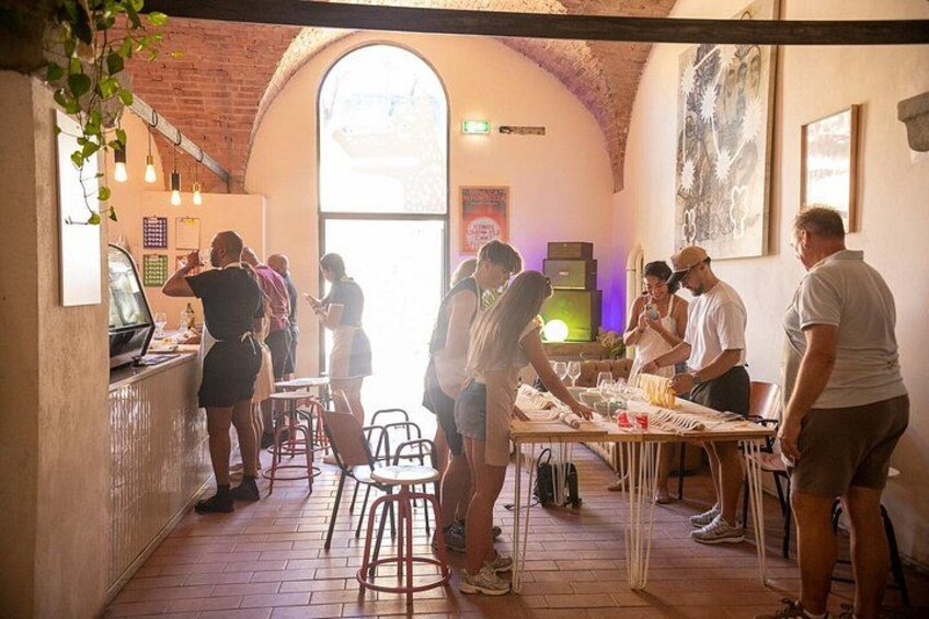 A restaurant interior with brick walls, a high arched window, and patrons dining. 2