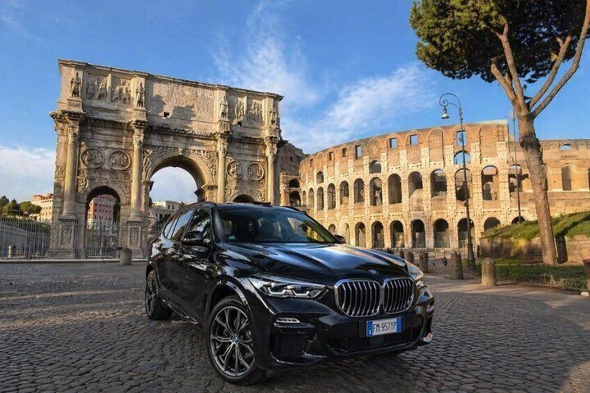 A black car parked in front of the Colosseum in Rome. 5