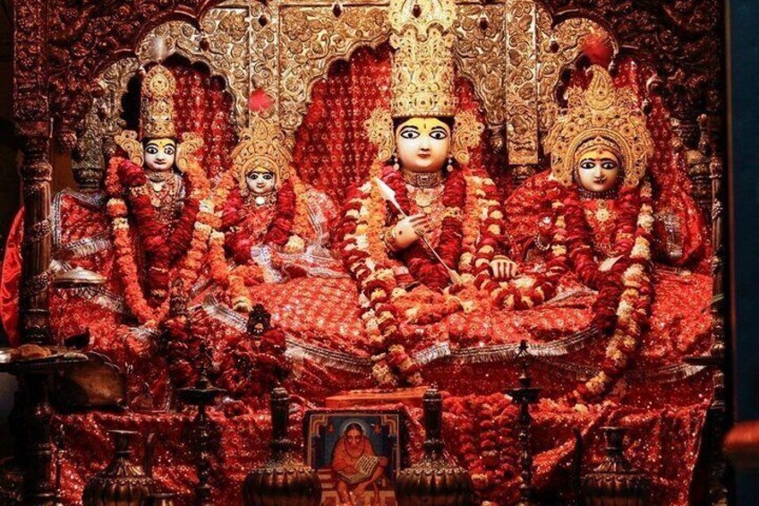 A deity with three attendants in traditional attire, seated on an ornate throne. 3