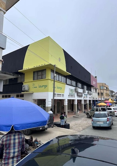 A street with a yellow building labeled 'Lemon Lounge,' a white building with 'GTP' signage, and a pink building with 'NPP' signage. 1