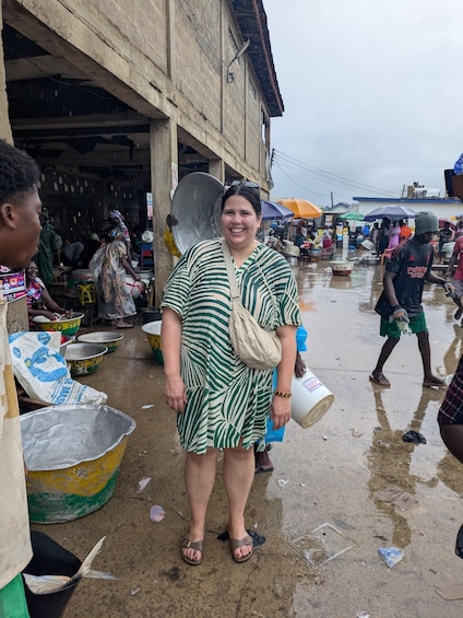 A market scene with people, large containers, and a building in the background. 3