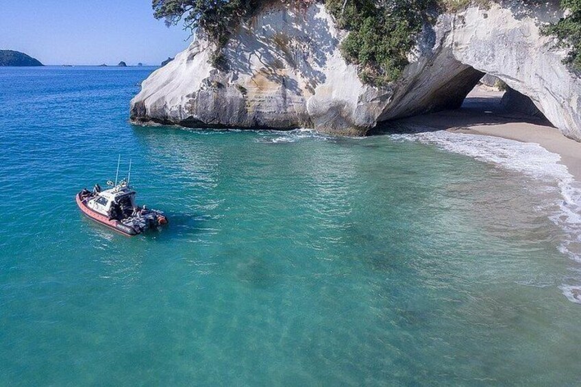 Un bateau près d’une côte rocheuse, sur une eau turquoise et limpide. 1