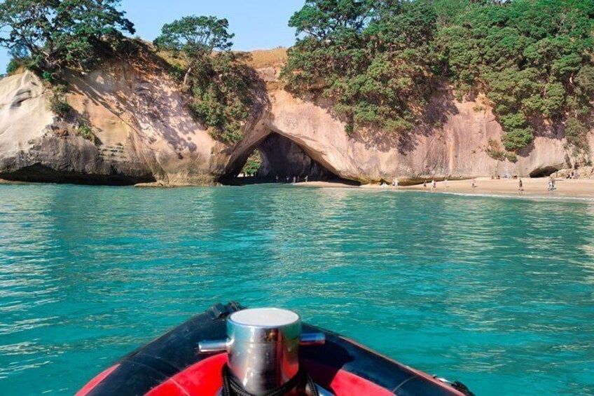 Un bateau orné d’une sorte de coupe métallique à l’avant, une mer turquoise et une arche rocheuse naturelle. 1