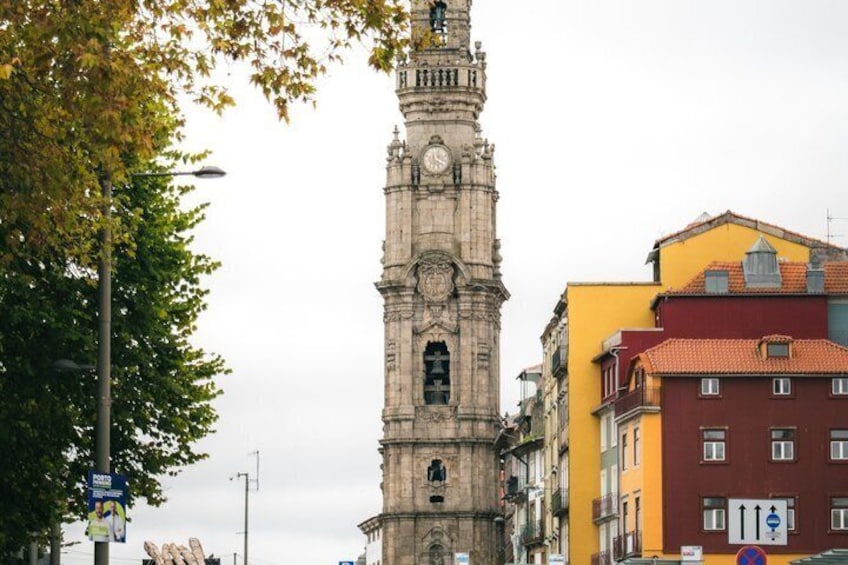 A historic clock tower with a clock face, surrounded by buildings with colorful facades. 4
