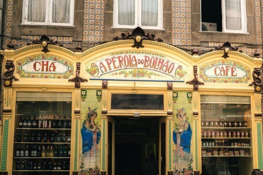 A building facade with ornate signage for 'CHA' and 'Aperola do Bolhão' cafe, featuring traditional Portuguese architectural details. 2