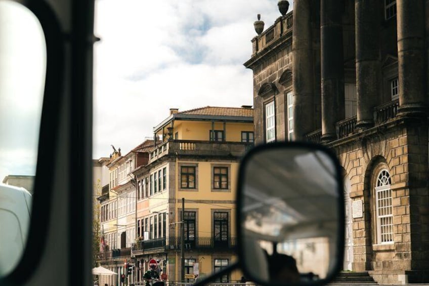 A street with historic buildings, a bus, and a clear sky. 5