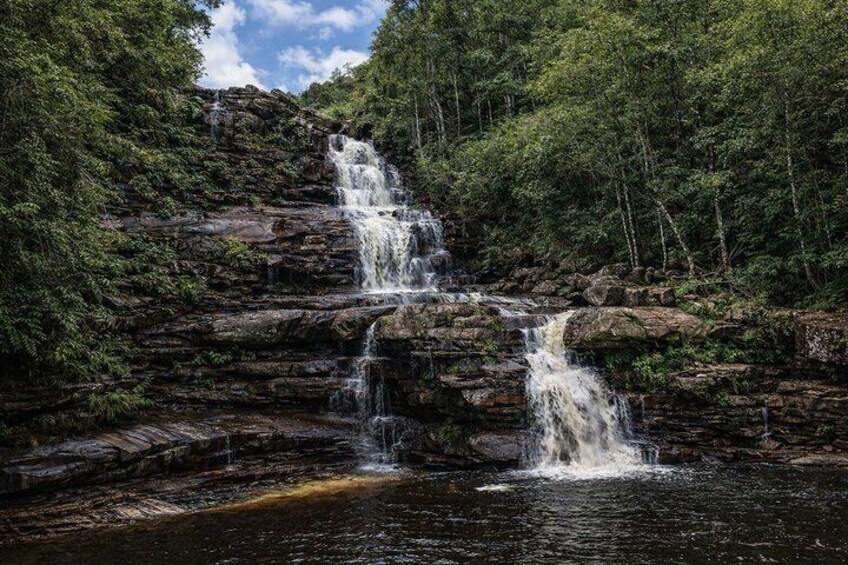Ein mehrstufiger Wasserfall, umgeben von dichtem Wald. 4