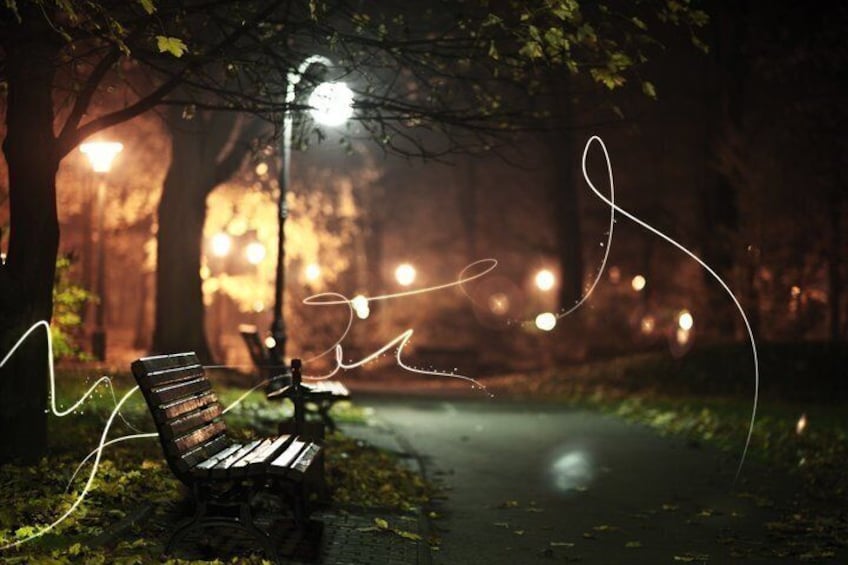 A park bench under a streetlight at night. 4