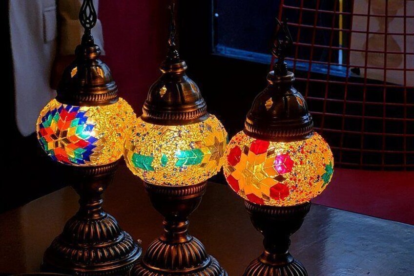 Three ornate, illuminated glass lamps with intricate mosaic patterns. 2