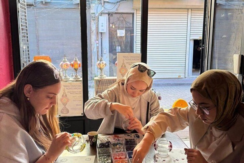 Three people sitting at a table with food items and drinks. 5