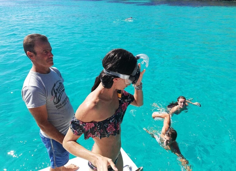 A man and a woman snorkeling in a clear blue ocean. 4