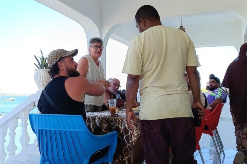 Des personnes dînent sur un bateau, avec vue sur la mer. 5