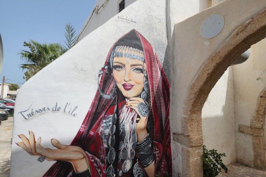 A mural of a woman in traditional attire, with the text 'Trésors de l'ile' visible. 1