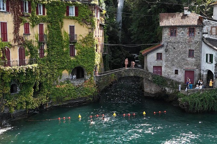Une rivière où l’on peut se baigner, un pont et des bâtiments aux volets rouges. 2