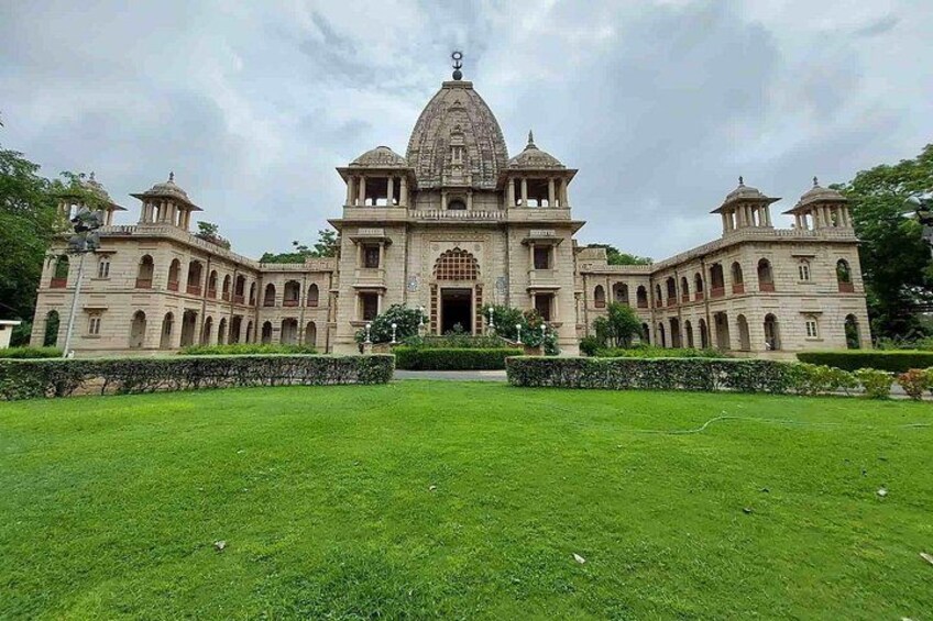 A large, historic building with a central dome and multiple smaller domes, surrounded by a well-maintained lawn. 3