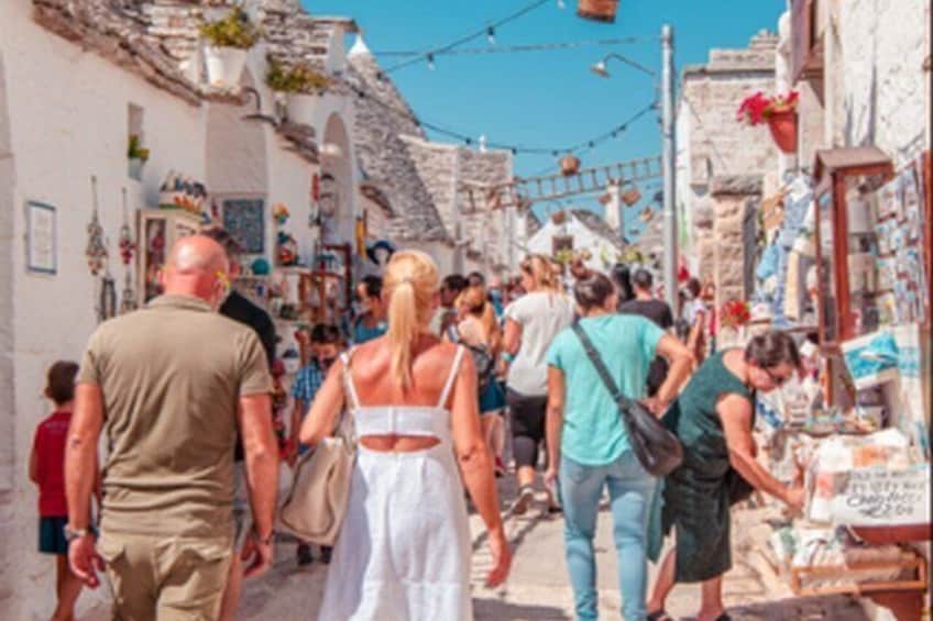 A crowded street with people walking, shops, and traditional architecture. 2