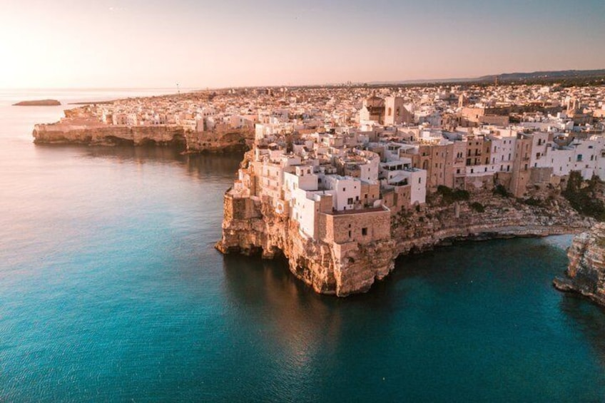A coastal town with buildings perched on a cliff, overlooking the sea. 1