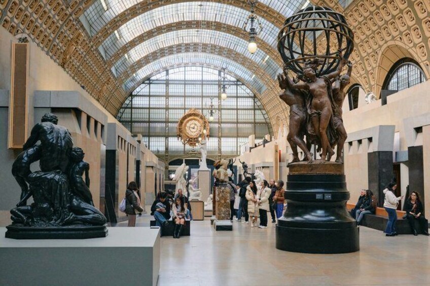 A spacious museum interior with a large globe sculpture and classical statues. 1