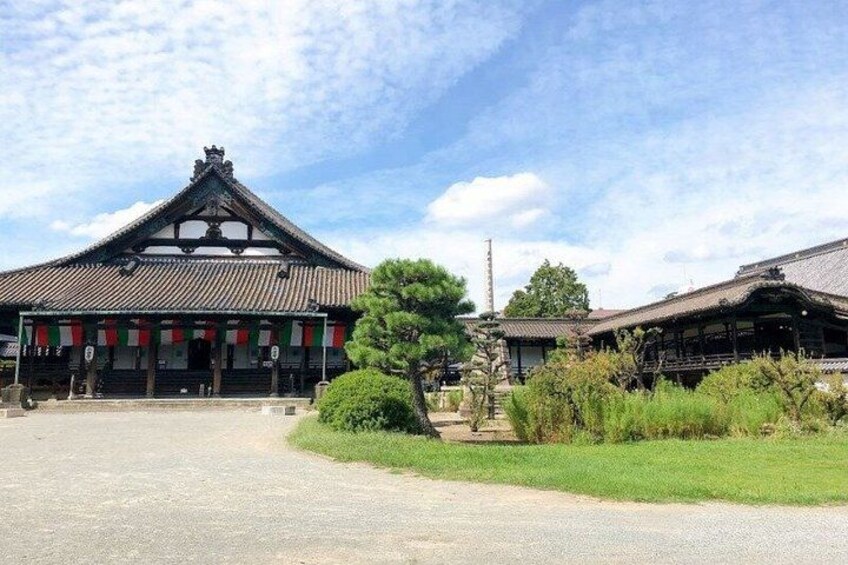 A traditional Japanese building with a tiled roof and a stone lantern in front. 3