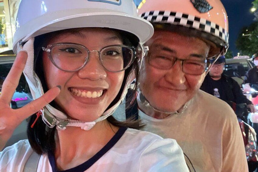 Two people wearing helmets, one with a checkered pattern and the other with a solid color. 1
