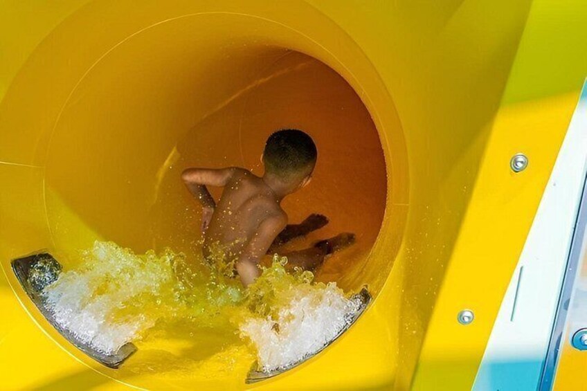 A child sliding down a yellow water slide. 3